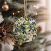 a ceramic ornament hanging from a christmas tree