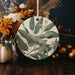 a picture of a plate with flowers and leaves on it