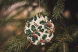 a ceramic ornament hanging from a christmas tree