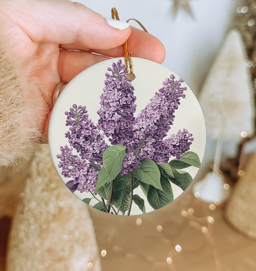 a person holding a purple flower ornament in their hand