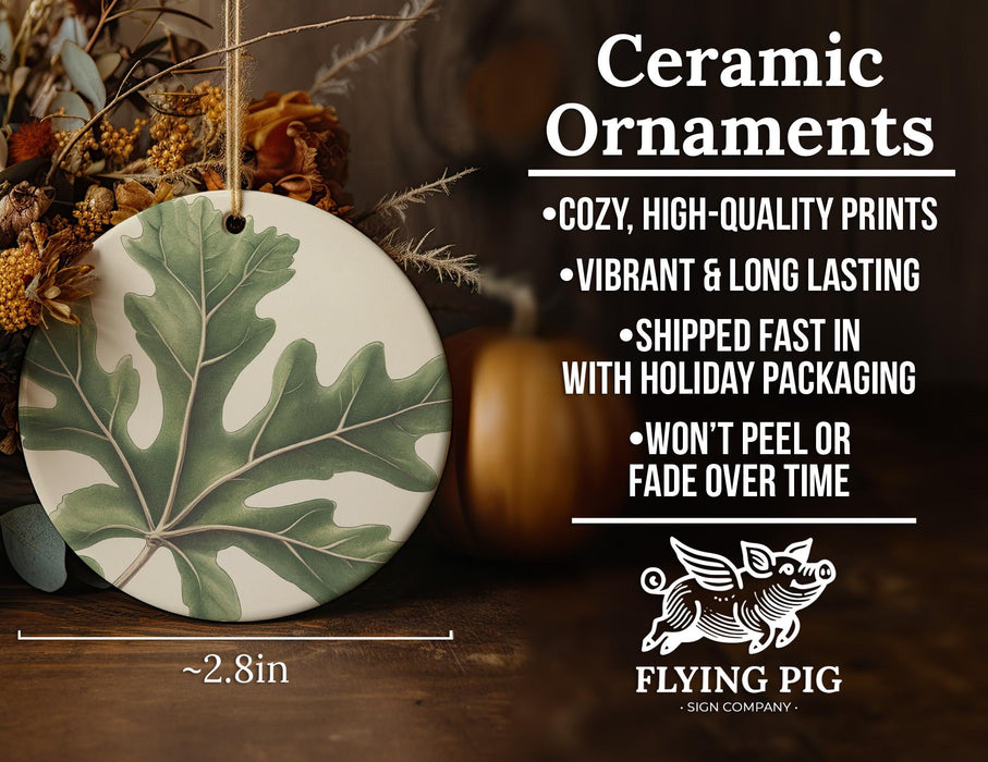 a ceramic ornament with a green leaf on it