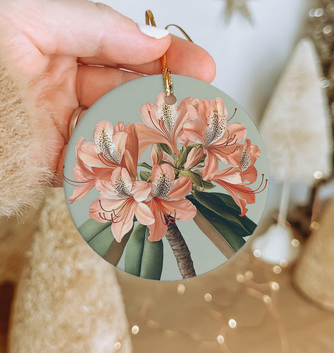 a person holding a round ornament with flowers on it