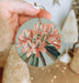 a person holding a round ornament with flowers on it