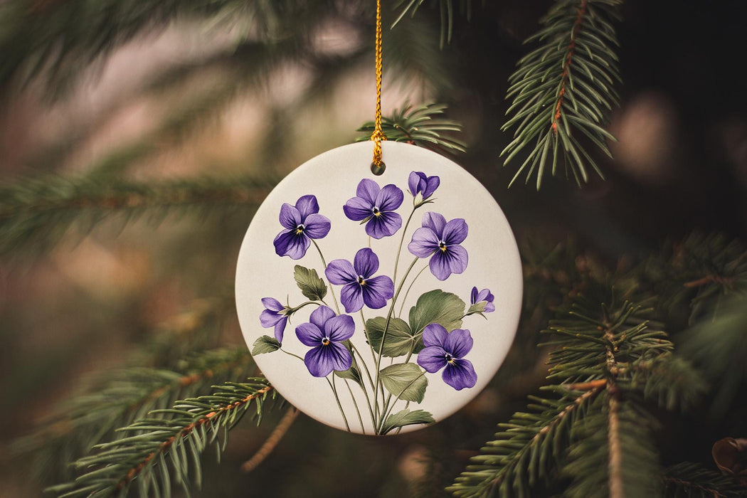 a white ornament with purple flowers hanging from a tree