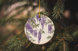a ceramic ornament with purple flowers hanging from a tree