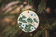 a ceramic ornament hanging from a christmas tree