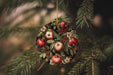 a christmas ornament hanging from a pine tree