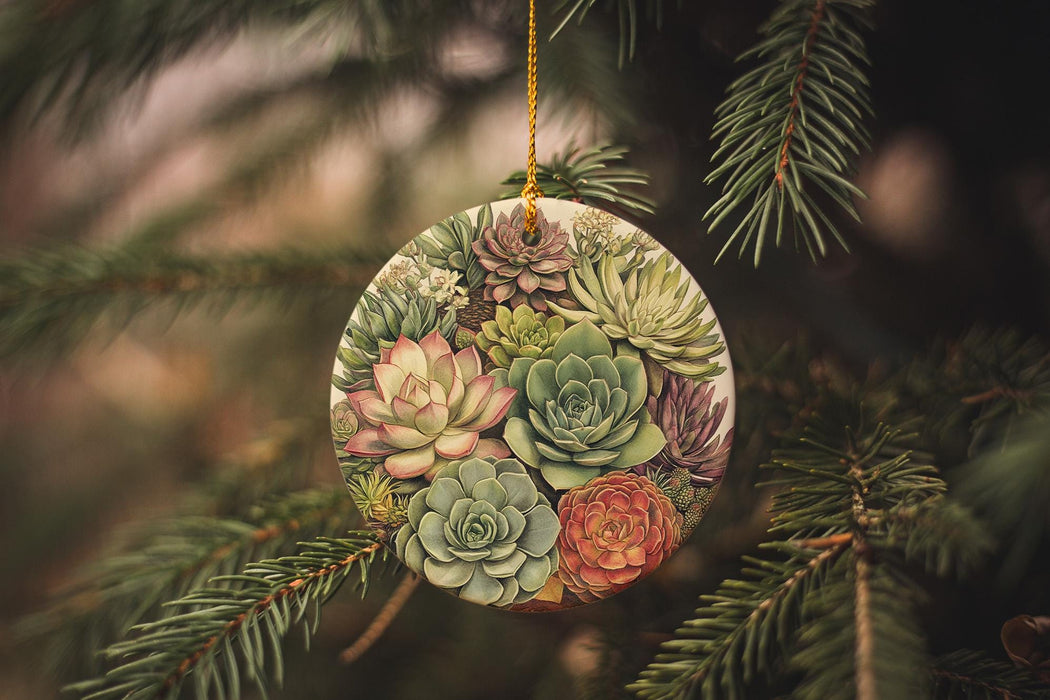 a ceramic ornament with succulents hanging from a pine tree