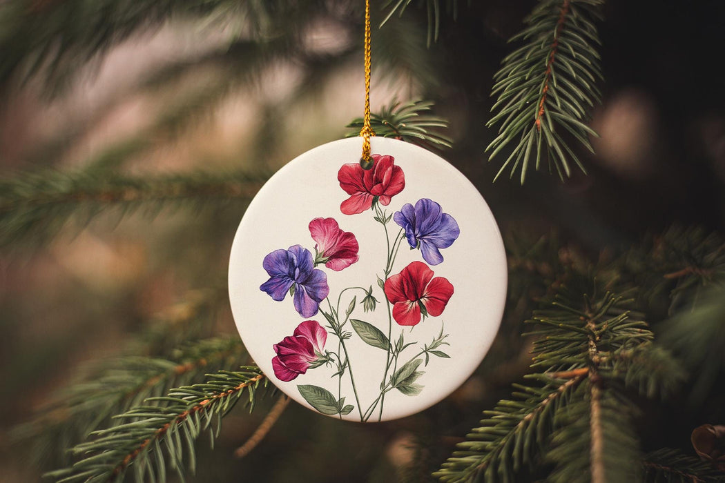 a ceramic ornament with flowers hanging from a tree