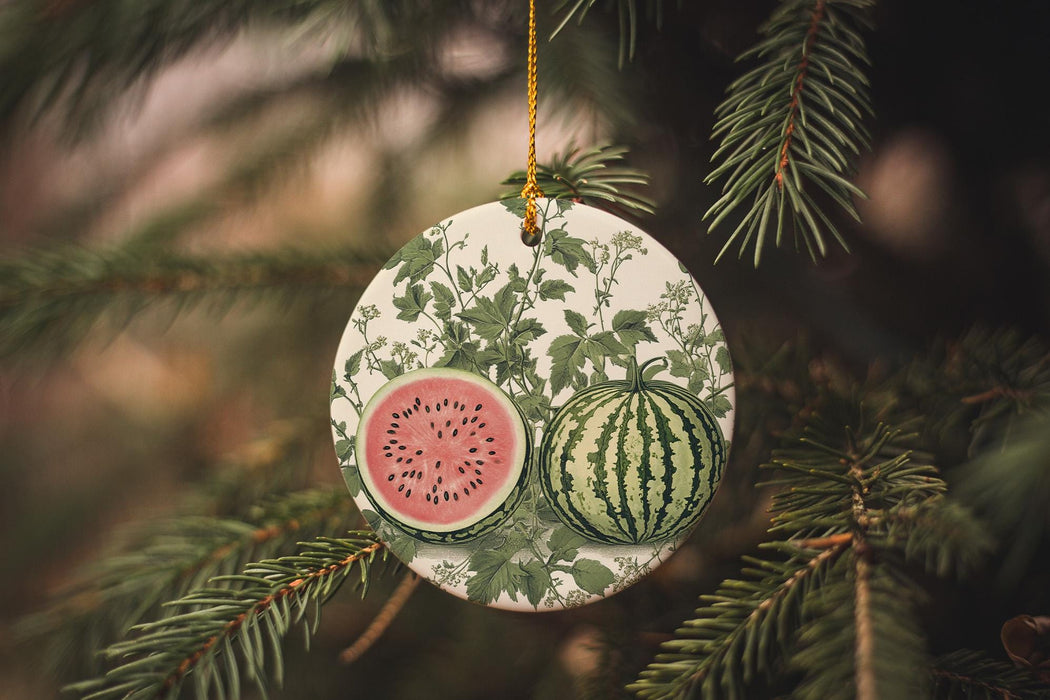 a watermelon ornament hanging from a pine tree