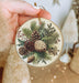 a person holding a christmas ornament in their hand