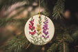 a ceramic ornament with flowers hanging from a tree