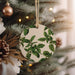 a ceramic ornament hanging from a christmas tree