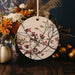 a white ceramic ornament with red berries and leaves