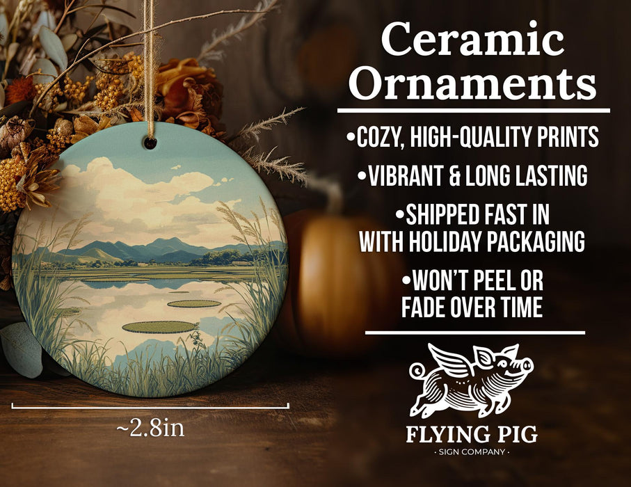 a ceramic ornament with a painting of a lake