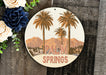 a sign that says palm springs next to a bouquet of flowers