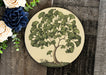 a plate with a tree painted on it next to flowers