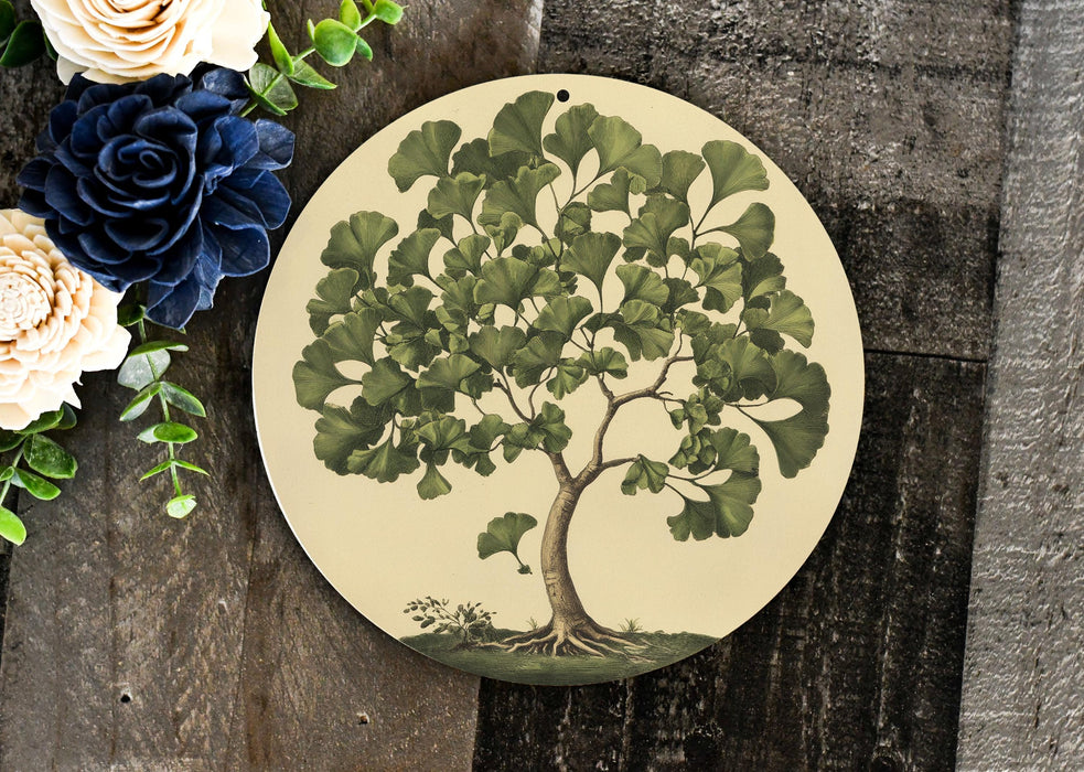 a plate with a tree painted on it next to flowers