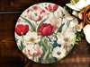 a plate with flowers painted on it next to a bouquet of flowers