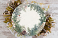 a white plate with a green and red wreath on it