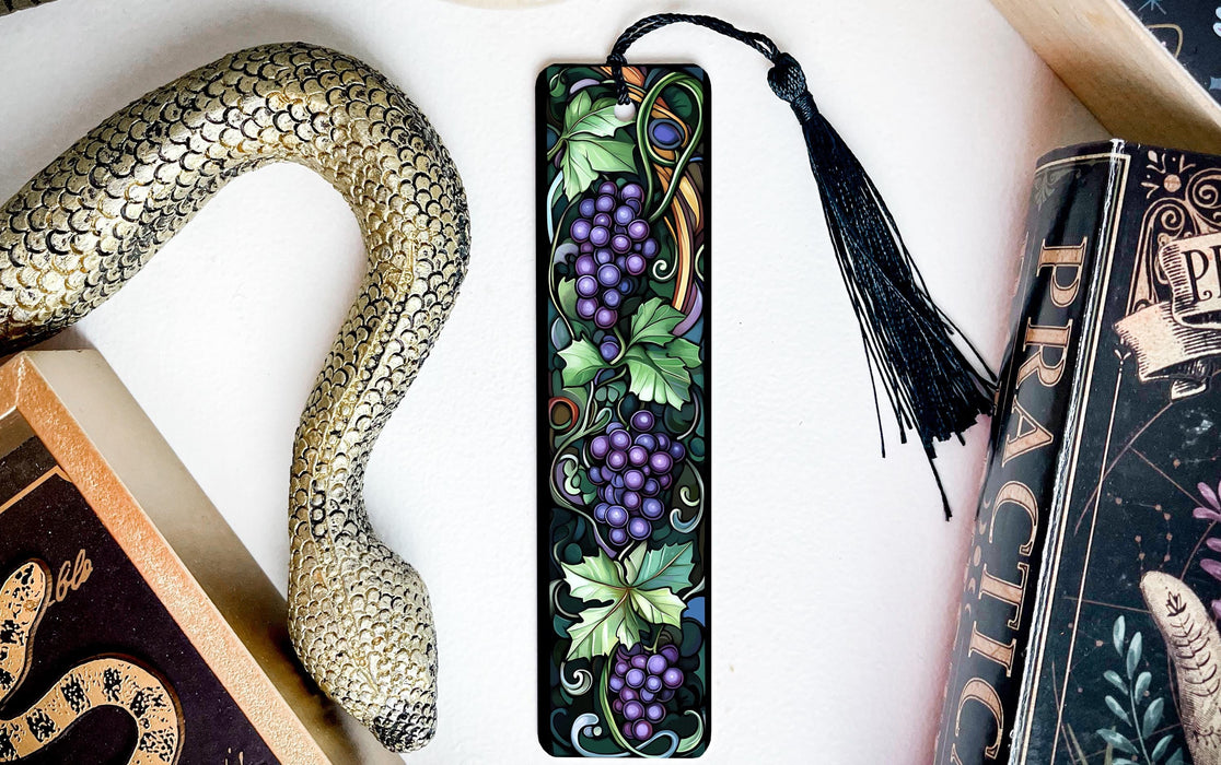 a bookmark with grapes and a snake on it
