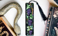 a bookmark with grapes and a snake on it
