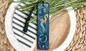 a blue bookmark sitting on top of a white plate