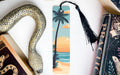 a bookmark with a snake on it next to a book
