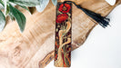 a bookmark with a red flower and a black tassel