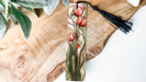 a piece of wood with a tassel hanging from it