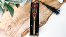 a wooden clock with a skeleton and a tassel hanging from it