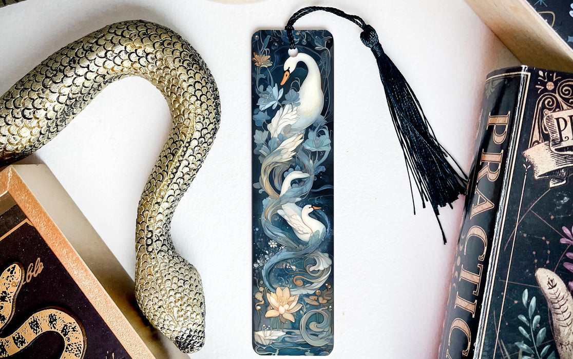 a snake, a bookmark, and two books on a table