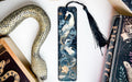 a snake, a bookmark, and two books on a table