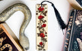 a bookmark with a snake and roses on it
