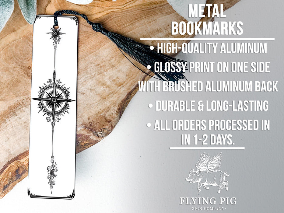 a metal bookmark with a black tassel on it