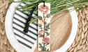 a bookmark with flowers on it sitting on a plate