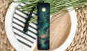 a green bookmark sitting on top of a white plate
