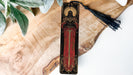 a wooden clock with a tassel hanging from it's side