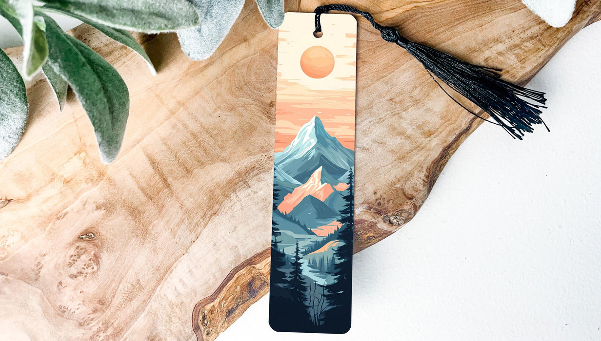 a wooden bookmark with a mountain scene on it