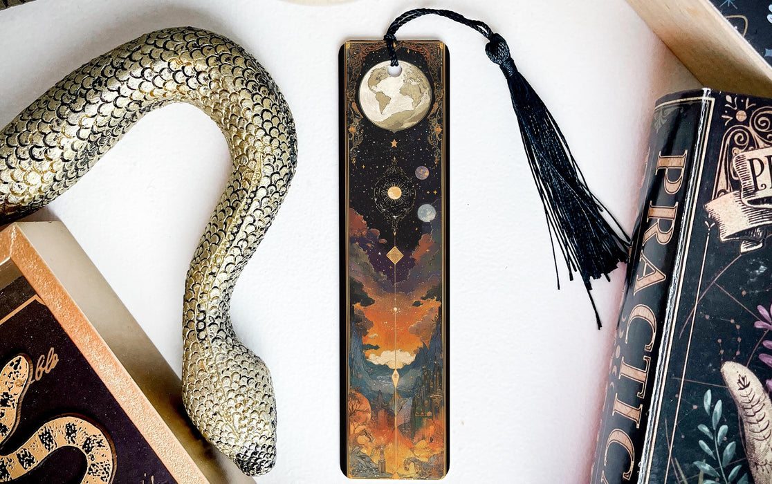 a bookmark with a snake on it next to a book