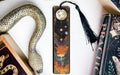 a bookmark with a snake on it next to a book
