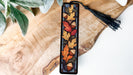 a wooden piece with a tassel hanging from it
