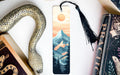 a bookmark with a picture of a mountain and a snake on it