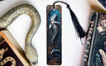 a bookmark with a mermaid on it next to books