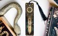 a bookmark with a snake on it next to some books