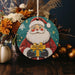 a christmas ornament with a santa clause holding a present