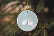 a blue ornament with a pair of baby's shoes hanging from a