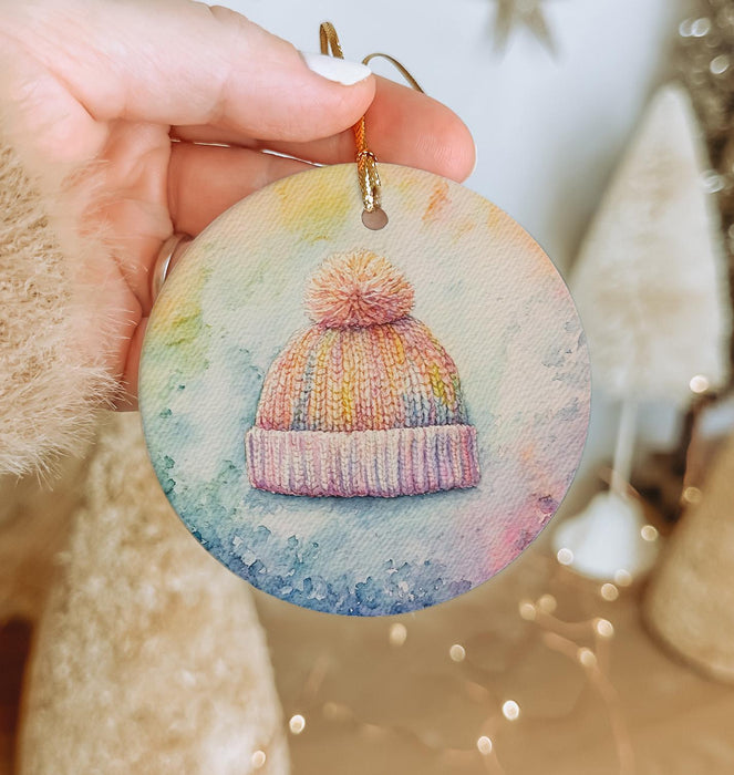 a person holding a small ornament with a hat on it