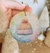 a person holding a small ornament with a hat on it