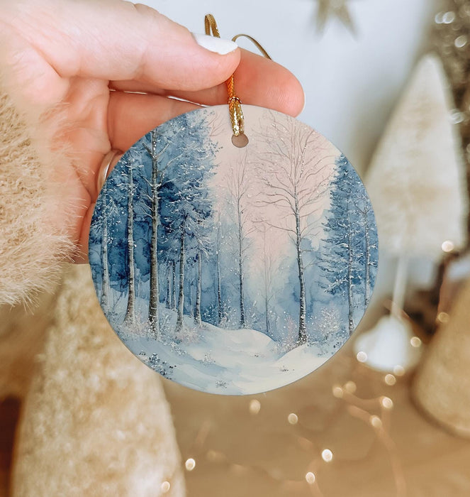 a person holding a small ornament with a snowy scene on it